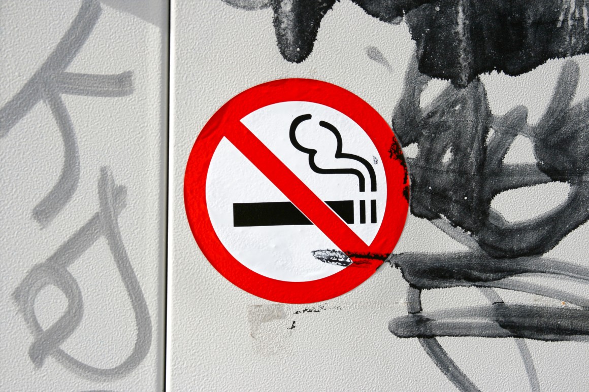 Non smoking sign and graffiti on wall