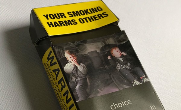 A photo of an empty cigarette pack showing NZ warning label: "Your smoking harms others"